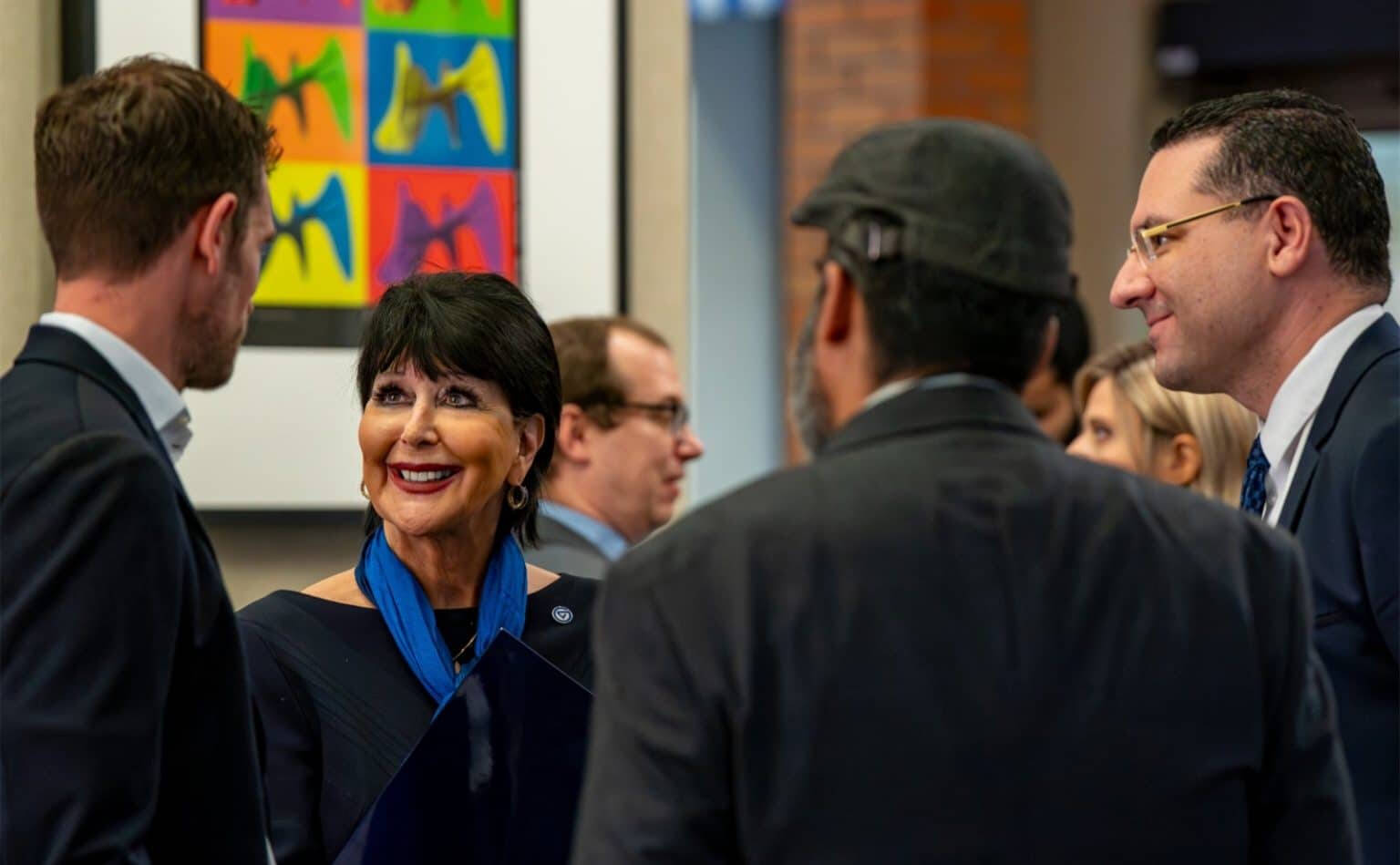 GVSU President Philomena V. Mantella and College of Computing Dean Marouane Kessentini, far right, talk with some attendees before the press conference.
